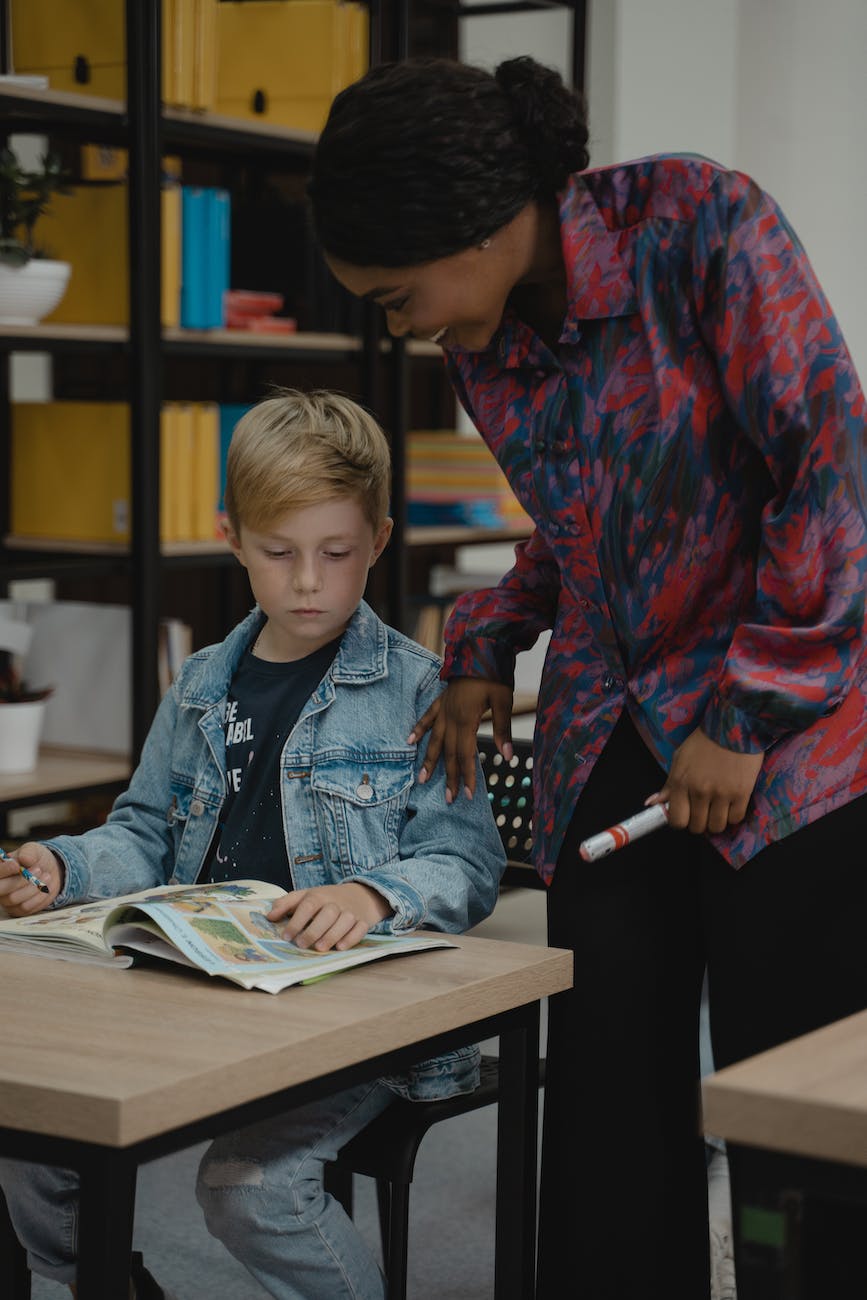 teacher standing beside a student