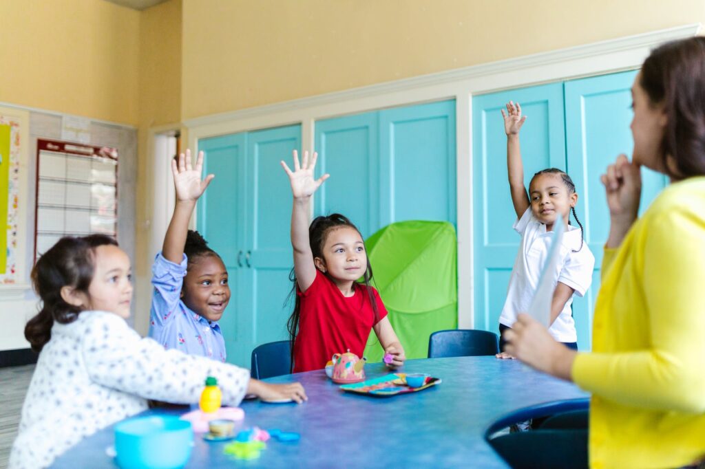 group of kids sitting on chair in front of table